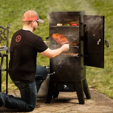 Ruben using a gas smoker in the backyard of his home.