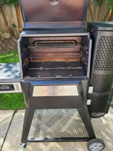 The inside of a Masterbuilt 560charcoal smoker being reviewed by Pioneer Smoke Houses.