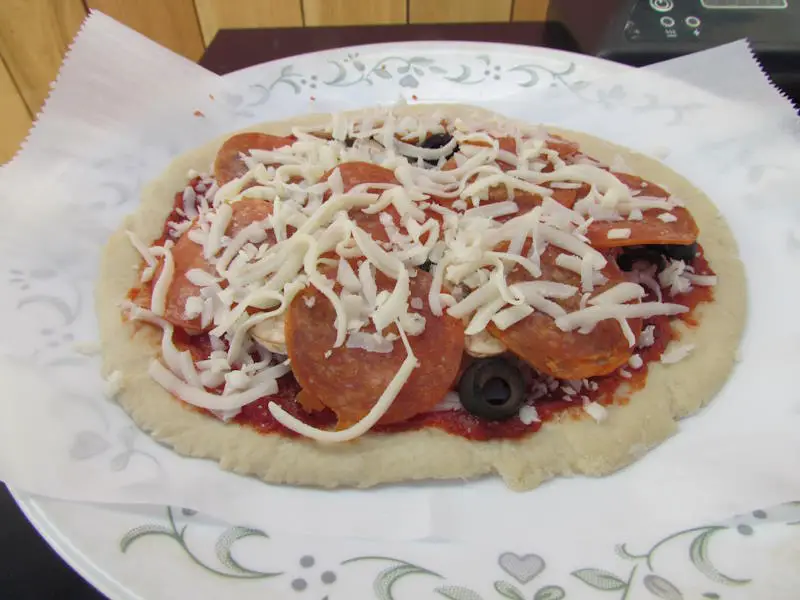 home-made loaded pepperoni mini pizza ready to go into the masterbuilt electric smoker