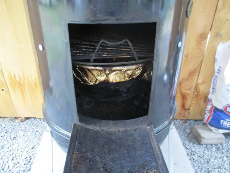 The Weber Smokey Mountain side door open so you can add more charcoal
