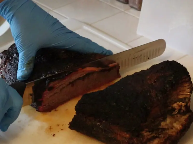 slicing meat smoked on the Weber Smokey Mountain Cooker for maximum tenderness